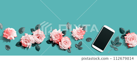 Smartphone with pink roses overhead view 112679814