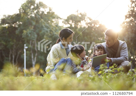 happy asian family having a good time outdoors in city park happy asian family having a good time outdoors in city park 112680794
