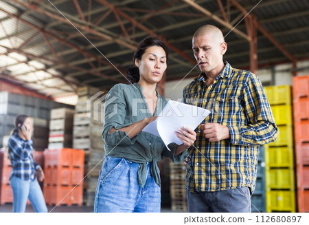 Man and woman talking about documentation Man and woman talking about documentation 112680897