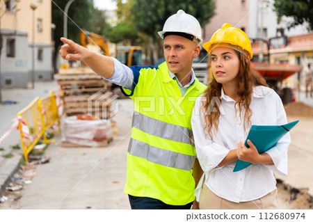 Architect woman and foreman discussing in construction site 112680974