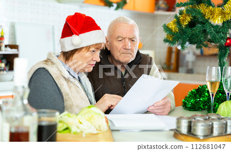 Aged family trying to pay utility bills before new year dinner Aged family trying to pay utility bills before new year dinner 112681047