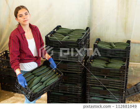 Woman with boxes of cucumbers 112681049