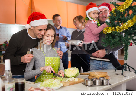 Woman cooking for Christmas dinner, happy family in kitchen Woman cooking for Christmas dinner, happy family in kitchen 112681058