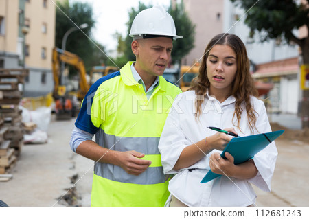 Architect woman and foreman discussing in construction site 112681243