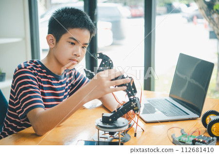 Asian boy learning and studying the work of technology robots.homeschool and science for tech project. playing childhood kids hobby leisure lifestyle people toys robotics technology. 112681410