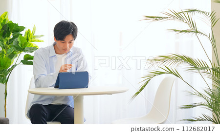 A man working on a tablet in the office A man working on a tablet in the office 112682017