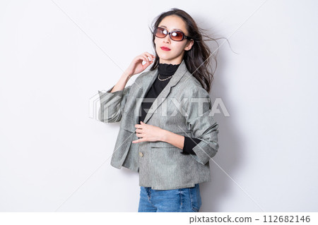 一名 30 多歲的女性，穿著休閒夾克和太陽眼鏡 112682146