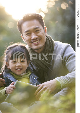 outdoor portrait of an asian father and daughter 112682229
