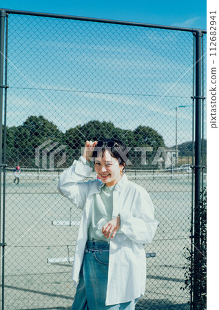 Stylish woman with a short cut hydrating outside Stylish woman with a short cut hydrating outside 112682941