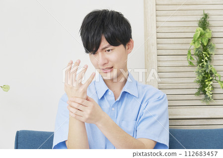 young man with numb hands 112683457