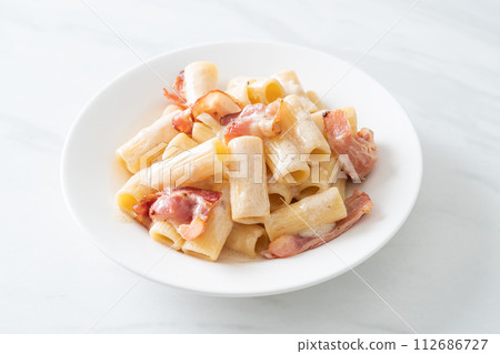 spaghetti rigatoni pasta with white sauce and bacon 112686727