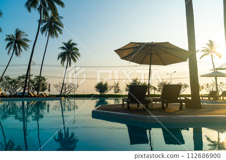 umbrella with bed pool around swimming pool with ocean sea background umbrella with bed pool around swimming pool with ocean sea background 112686900