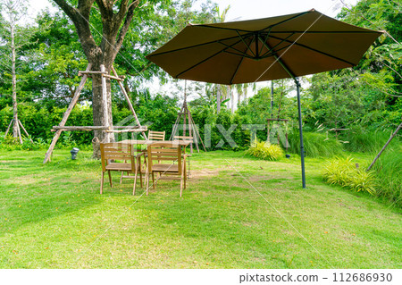 wood table and chair in garden 112686930