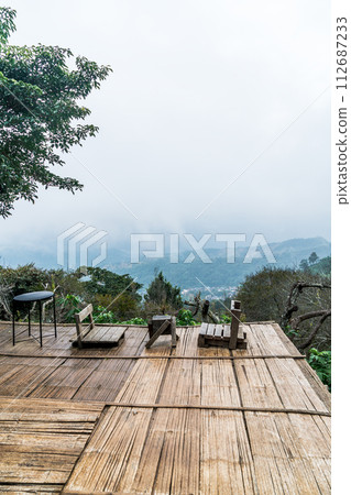 chair on balcony with mountain hill and foggy background 112687233