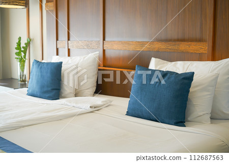 comfortable pillows and white pillows on bed 112687563
