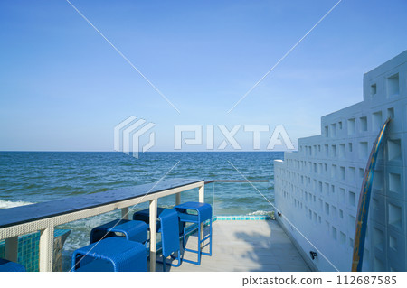 desk and bar stool near swimming pool with sea background 112687585