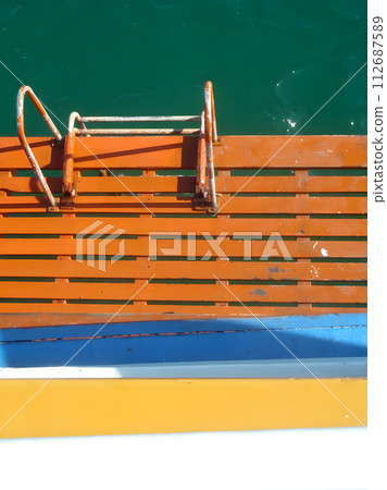 Wooden boat steps to the sea under a summer sky Wooden boat steps to the sea under a summer sky 112687589