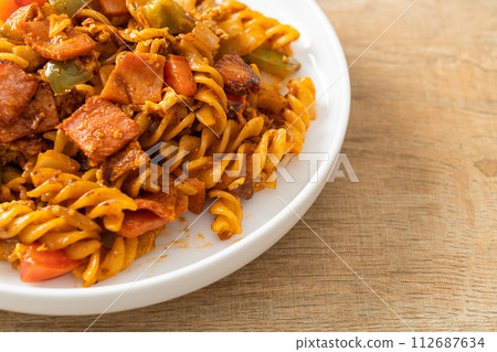 fusilli pasta with ham and tomatoes sauce 112687634