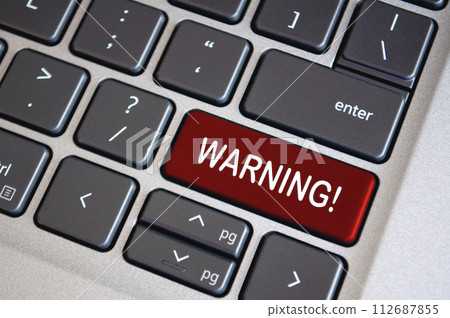 Warning text on dark red laptop keyboard. Security and warning concept 112687855