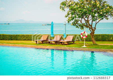 chair pool and umbrella around swimming pool 112688317