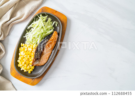 grilled salmon fillet steak on hot plate 112688455