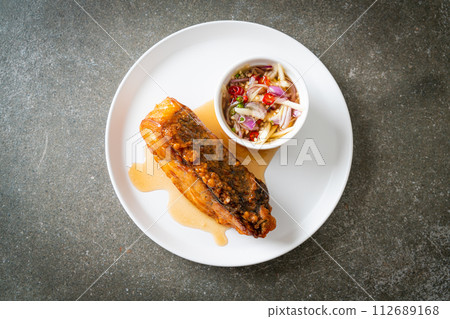 fried snapper fish with fish sauce and spicy salad 112689168
