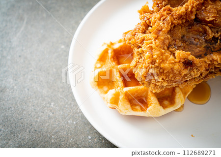 fried chicken waffle with honey or maple syrup 112689271