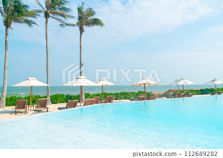umbrella with bed pool around swimming pool with ocean sea background 112689282
