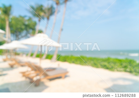 abstract blur umbrella with beach chair for background 112689288