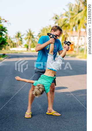 Father son have fun. Man holds child's leg upside down head. Joy happiness childhood paternity delight 112689290