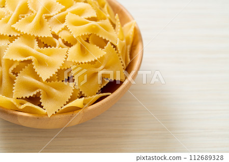 Dry uncooked farfalle pasta in bowl Dry uncooked farfalle pasta in bowl 112689328