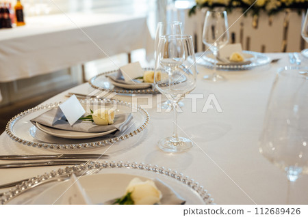 A very beautiful festive table with candles, plates and glasses. Cool room decor A very beautiful festive table with candles, plates and glasses. Cool room decor 112689426