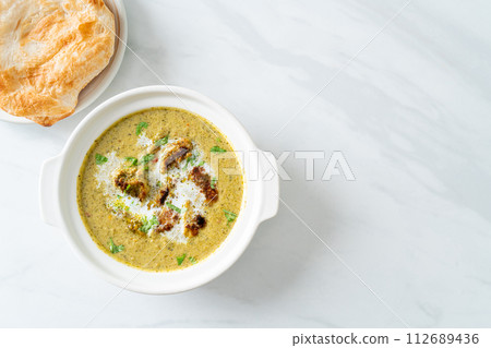 Afghani chicken in green masala curry or Hariyali tikka chicken hara masala with roti or naan bread 112689436