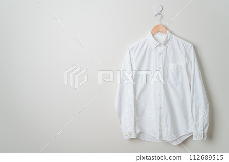 hanging shirt with wood hanger on wall 112689515