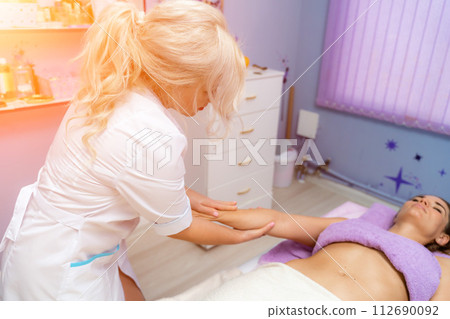 Blonde massage therapist massaging a woman. Woman getting a massage at the spa Blonde massage therapist massaging a woman. Woman getting a massage at the spa 112690092