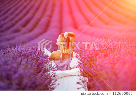 Woman lavender field. A middle-aged woman sits in a lavender field and enjoys aromatherapy. Aromatherapy concept, lavender oil, photo session in lavender Woman lavender field. A middle-aged woman sits in a lavender field and enjoys aromatherapy. Aromatherapy concept, lavender oil, photo session in lavender 112690095