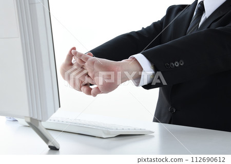 Businessman stretching during desk work 112690612