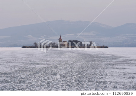 Beautiful old church of St. Linhart. Catholic temple village of Musov - Pasohlavky, Czech Republic. Photo of winter landscape with sunset on a dam New Mills (Nove Mlyny). 112690829