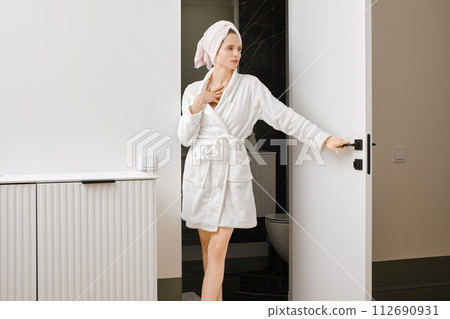 Young woman coming out of bathroom 112690931