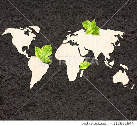 Ecology and zero waste concept. World map silhouette made of  cardboard and green leaves on black soil. Horizontal banner with eco paper texture. Global ecological resource. Copy space for text 112691644