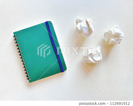 green notebook and crumpled paper green notebook and crumpled paper 112691912