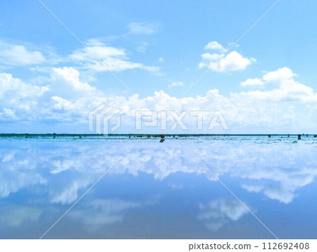 Blue sky and clouds reflected on the surface of the water 112692408
