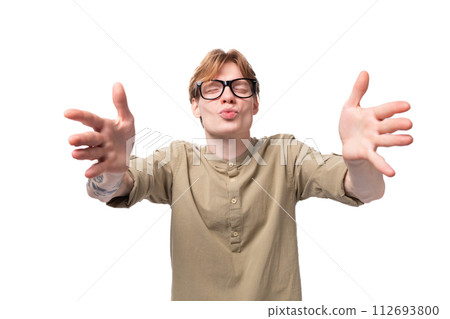 a young loving red-haired European man dressed in a light brown shirt with a tattoo sends an air 112693800