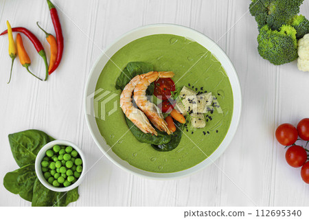 Seafood soup with spinach and croutons, mushrooms. Decorated with shrimps. Seafood soup with spinach and croutons, mushrooms. Decorated with shrimps. 112695340