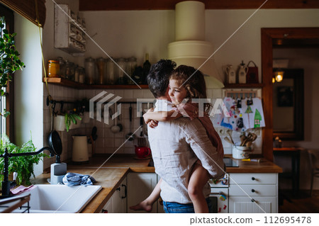 Daughter hugging father lovingly, looking at camera, smiling with gap-toothed grin. Unconditional paternal love, Father's Day concept. Daughter hugging father lovingly, looking at camera, smiling with gap-toothed grin. Unconditional paternal love, Father's Day concept. 112695478