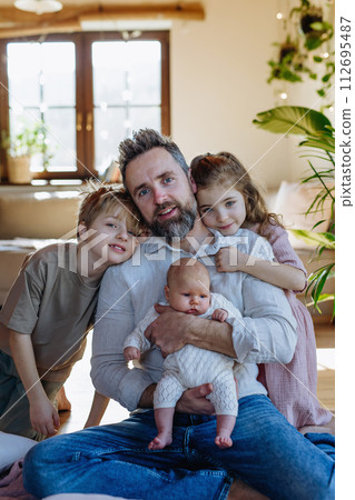 Portrait of father holding newborn baby, enjoying all his kids. New sibling. Unconditional paternal love, Father's Day concept. Portrait of father holding newborn baby, enjoying all his kids. New sibling. Unconditional paternal love, Father's Day concept. 112695487