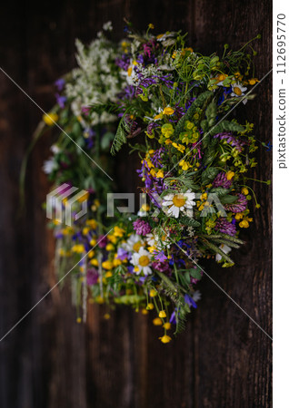 Beautiful floral wreath from meadow flowers. A colorful variety of summer wildflowers. 112695770