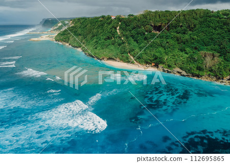 Beach coastline with turquoise ocean and waves in Bali. Aerial view Beach coastline with turquoise ocean and waves in Bali. Aerial view 112695865