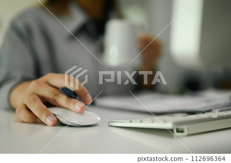 Close up of female office worker using computer mouse on desk Close up of female office worker using computer mouse on desk 112696364