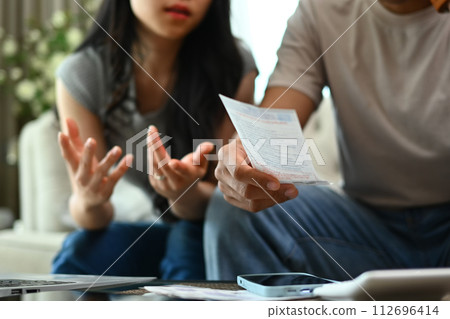 Cropped shot couple having financial problems, calculating their domestic budget in living room 112696414